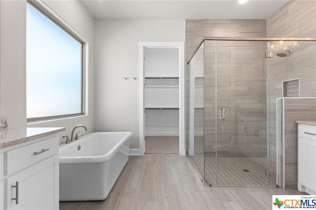 bathroom with hardwood / wood-style flooring, vanity, and independent shower and bath