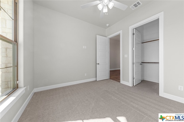 unfurnished bedroom featuring ceiling fan, a closet, and light colored carpet