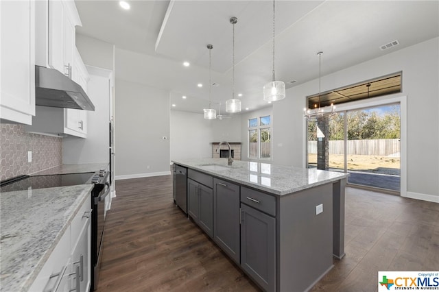 kitchen featuring light stone countertops, white cabinetry, sink, a kitchen island with sink, and appliances with stainless steel finishes