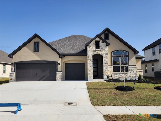 french country style house featuring a garage, driveway, stone siding, a front lawn, and stucco siding