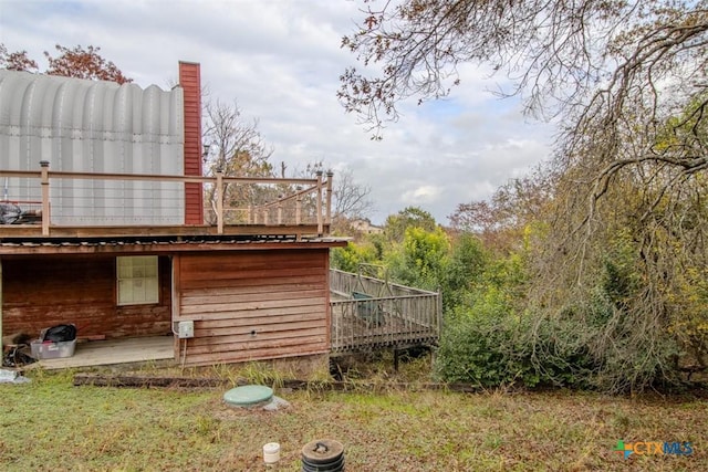 view of side of home featuring a lawn and a deck