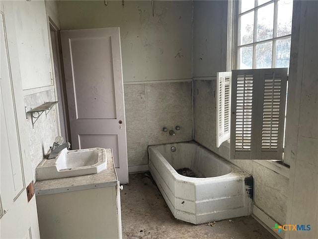 bathroom with a tub and vanity