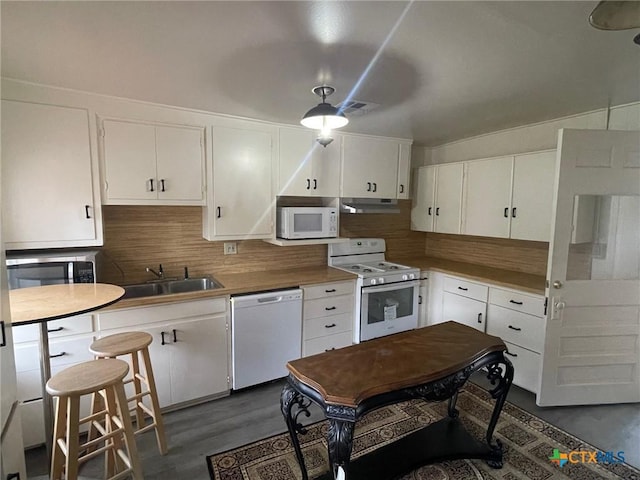 kitchen featuring white cabinetry, sink, dark hardwood / wood-style floors, backsplash, and white appliances