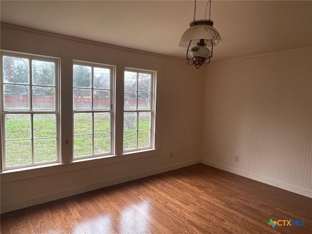 unfurnished room with wood-type flooring and ornamental molding