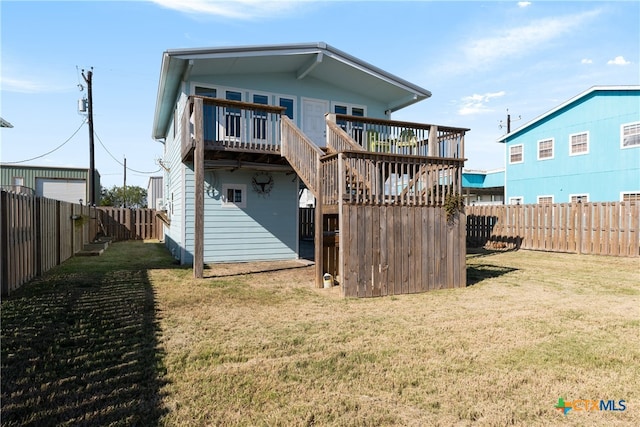 back of property with a lawn and a deck