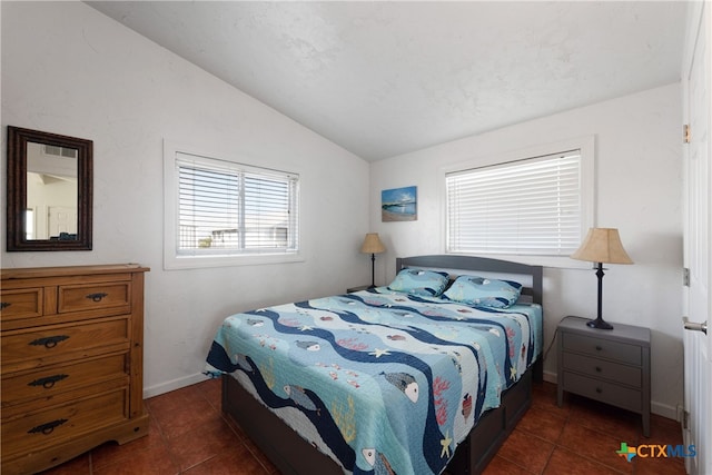 tiled bedroom with multiple windows and lofted ceiling