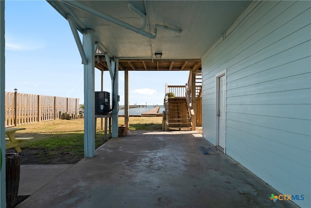 view of patio featuring a water view and central AC