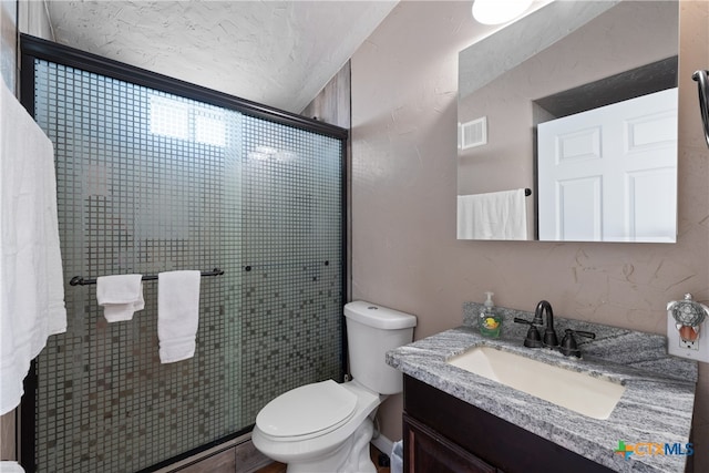 bathroom featuring vanity, toilet, and walk in shower