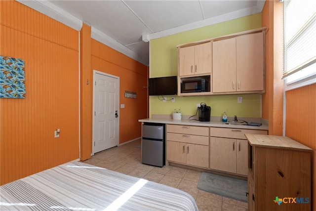 kitchen with stainless steel fridge, black microwave, light brown cabinets, and light tile patterned floors