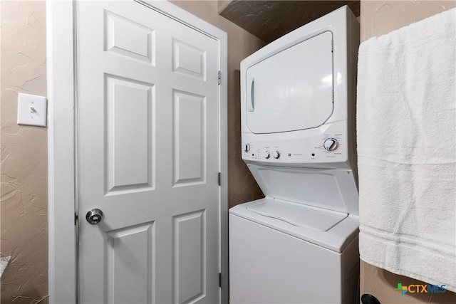 washroom featuring stacked washer / drying machine