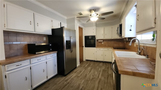 kitchen with white cabinets, tile countertops, sink, and black appliances