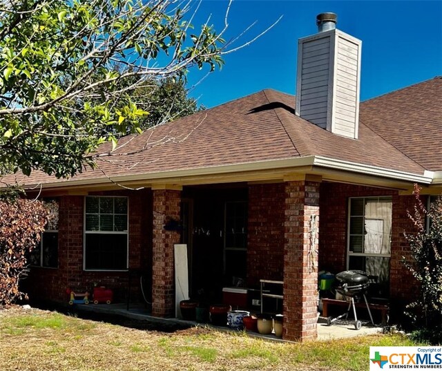 4305 Foster Ln, Killeen, TX 76549 - back of house with brick siding, roof with shingles, and a chimney