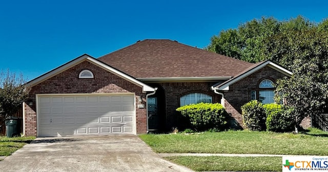 4305 Foster Ln, Killeen, TX 76549 - ranch-style home featuring brick siding, concrete driveway, a front yard, a garage, and roof with shingles