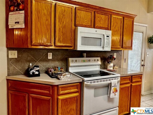 4305 Foster Ln, Killeen, TX 76549 - kitchen with white appliances, decorative backsplash, light countertops, and light tile patterned floors