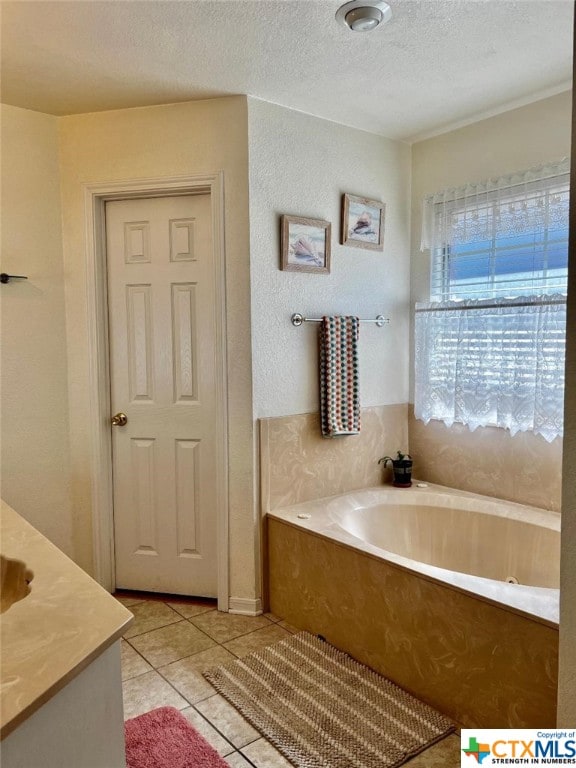 bathroom with vanity, tile patterned flooring, a bathing tub, and a textured ceiling