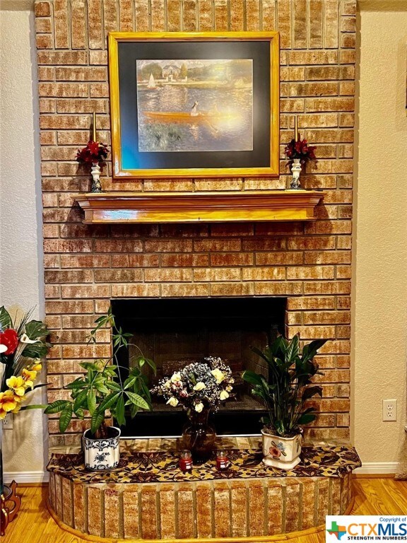 4305 Foster Ln, Killeen, TX 76549 - detailed view of a brick fireplace, wood finished floors, and baseboards