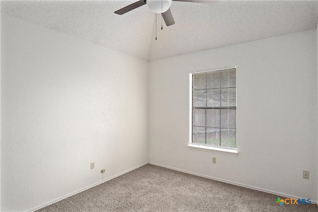 carpeted spare room with a textured ceiling and ceiling fan