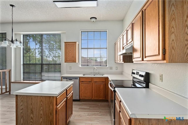 kitchen with plenty of natural light, sink, light hardwood / wood-style flooring, decorative light fixtures, and stainless steel appliances