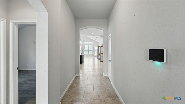 3542 Hurricane Trl, New Braunfels, TX 78130 - hallway with baseboards, arched walkways, and stone tile floors