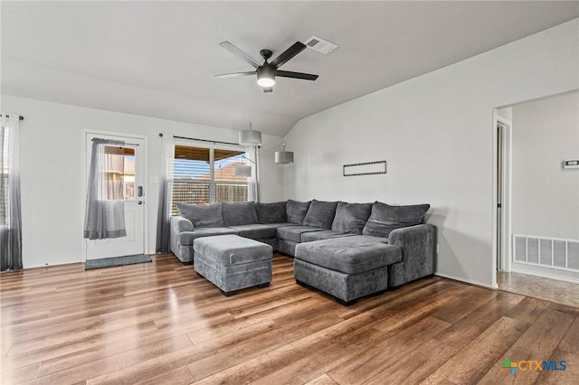 living room with ceiling fan, vaulted ceiling, and wood-type flooring