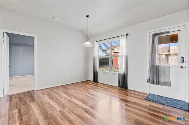 unfurnished dining area featuring hardwood / wood-style flooring and vaulted ceiling