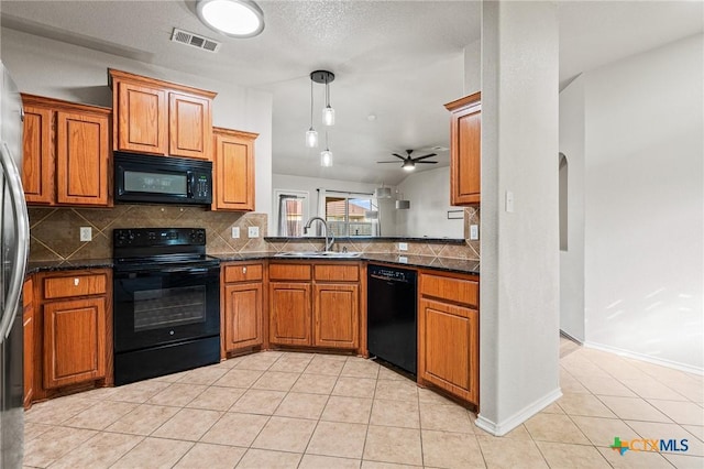 kitchen with black appliances, lofted ceiling, light tile patterned flooring, backsplash, and sink