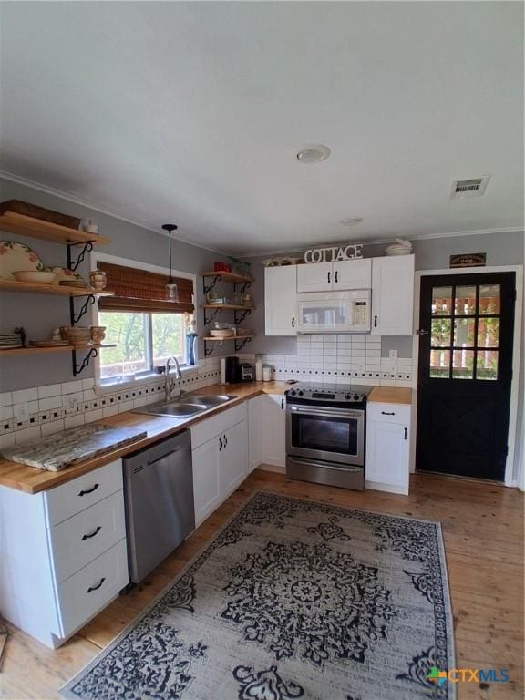 1837 Colleen Dr, Canyon Lake, TX 78133 - kitchen with appliances with stainless steel finishes, open shelves, a sink, tasteful backsplash, and ornamental molding
