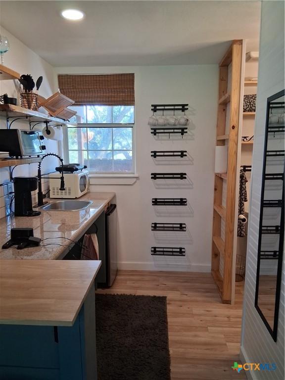 1837 Colleen Dr, Canyon Lake, TX 78133 - kitchen featuring open shelves, light wood-type flooring, a sink, baseboards, and butcher block countertops