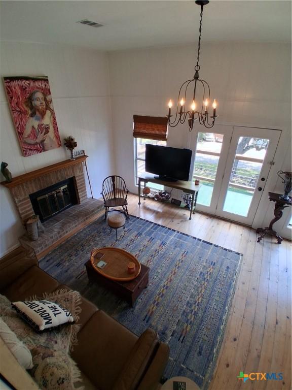 1837 Colleen Dr, Canyon Lake, TX 78133 - living area featuring hardwood / wood-style floors, a brick fireplace, and a chandelier