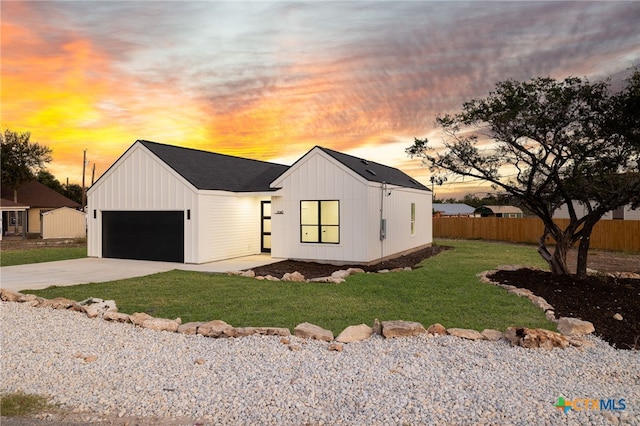 modern farmhouse style home featuring a garage and a lawn