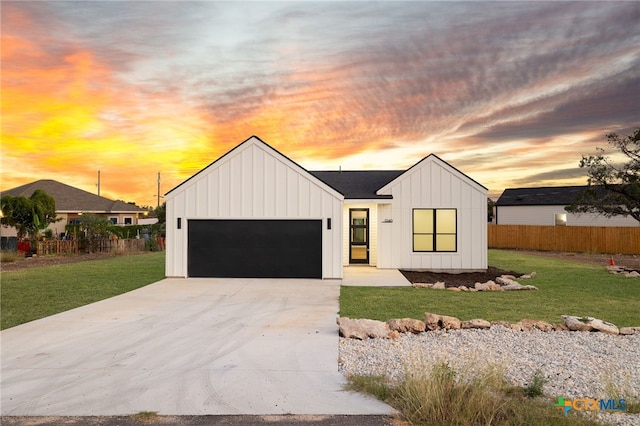 modern inspired farmhouse with a lawn and a garage