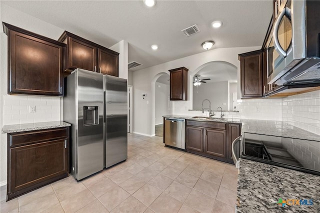 2048 Wigeon Way, Copperas Cove, TX 76522 - kitchen with appliances with stainless steel finishes, arched walkways, a ceiling fan, tasteful backsplash, and dark brown cabinets