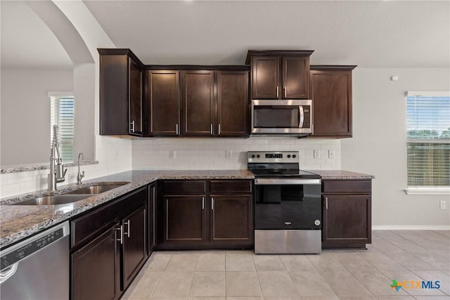 2048 Wigeon Way, Copperas Cove, TX 76522 - kitchen featuring appliances with stainless steel finishes, stone countertops, arched walkways, and plenty of natural light