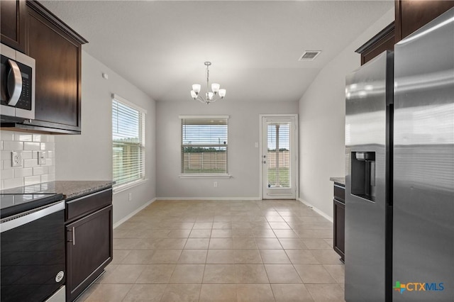 2048 Wigeon Way, Copperas Cove, TX 76522 - kitchen with stainless steel appliances, dark brown cabinets, healthy amount of natural light, dark stone counters, and vaulted ceiling