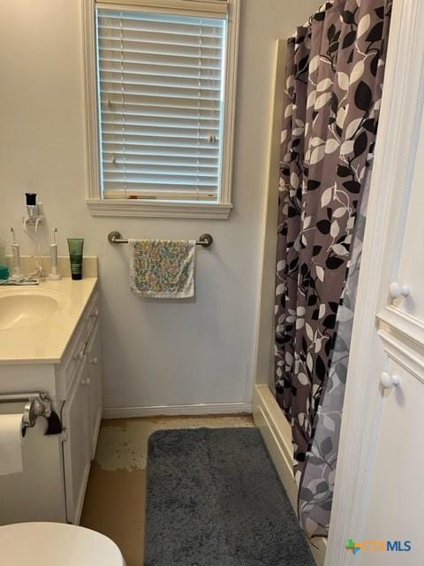 509 N St, Yoakum, TX 77995 - full bath with vanity, baseboards, toilet, and a shower with shower curtain