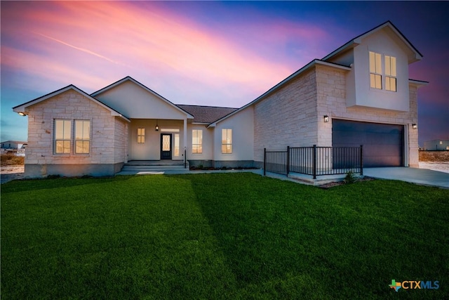 view of front of home featuring a garage and a lawn