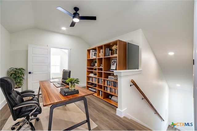 home office featuring ceiling fan, light wood-type flooring, and vaulted ceiling