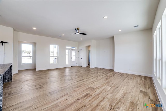 unfurnished living room with ceiling fan and light hardwood / wood-style flooring