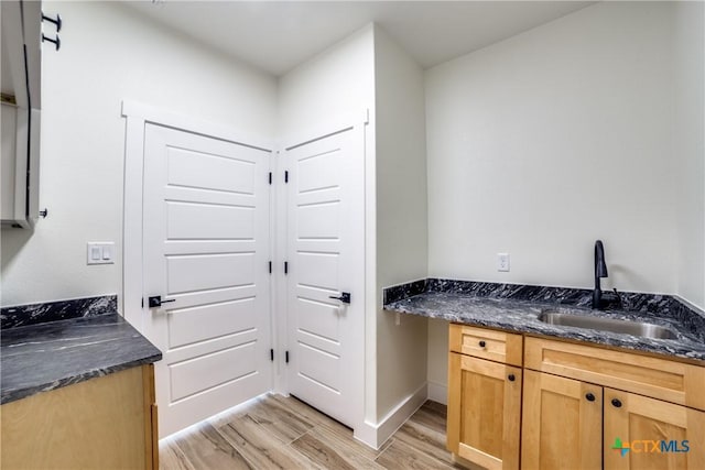 laundry room featuring light hardwood / wood-style flooring and sink