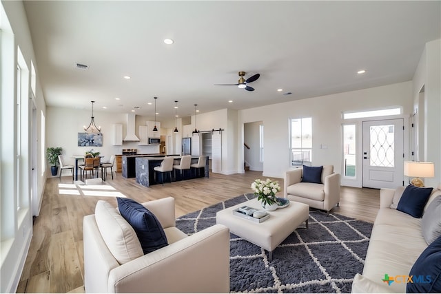 living room featuring ceiling fan and light hardwood / wood-style floors