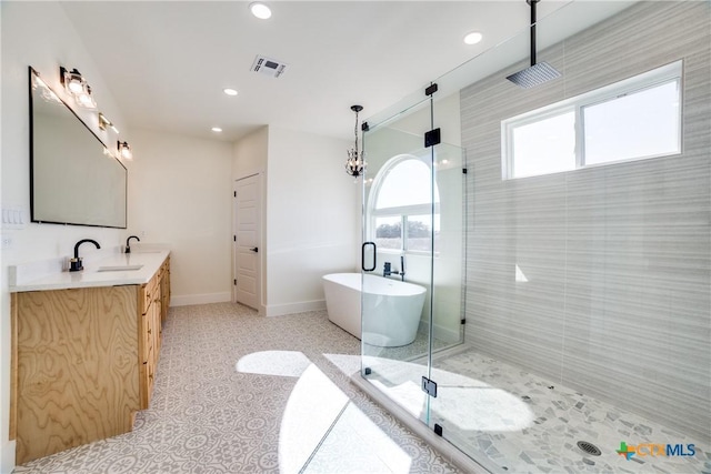 bathroom featuring separate shower and tub, vanity, and a chandelier