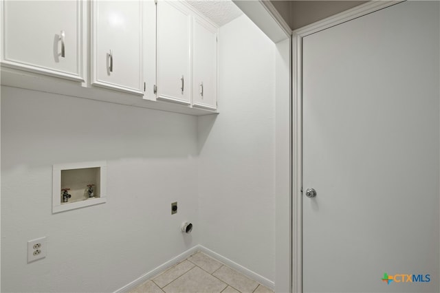 laundry area featuring cabinets, light tile patterned flooring, hookup for a washing machine, and electric dryer hookup