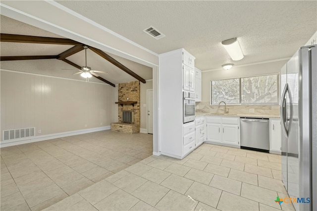 kitchen featuring ceiling fan, sink, light tile patterned floors, stainless steel appliances, and white cabinets