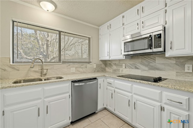 kitchen featuring stainless steel appliances, backsplash, white cabinetry, and sink