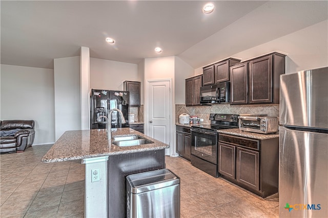 kitchen featuring black appliances, decorative backsplash, sink, a breakfast bar area, and a kitchen island with sink