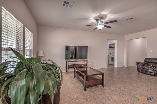 living room with ceiling fan and washer / dryer