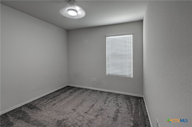 empty room featuring dark carpet