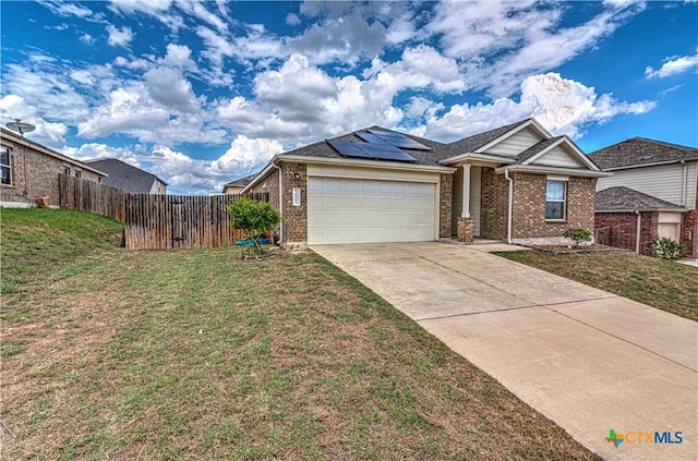 view of front of home featuring a garage, a front yard, and solar panels