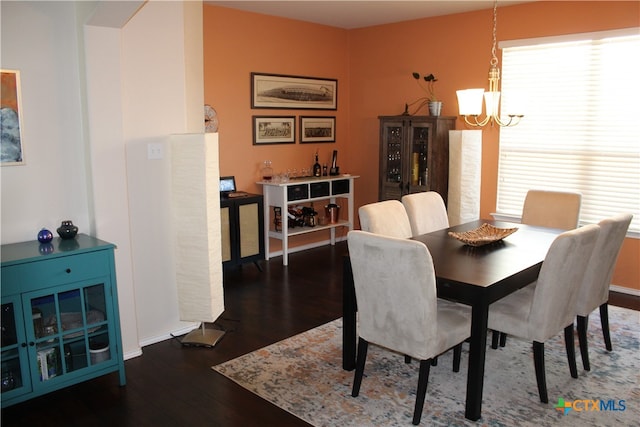 dining room featuring dark hardwood / wood-style floors, a healthy amount of sunlight, and a chandelier