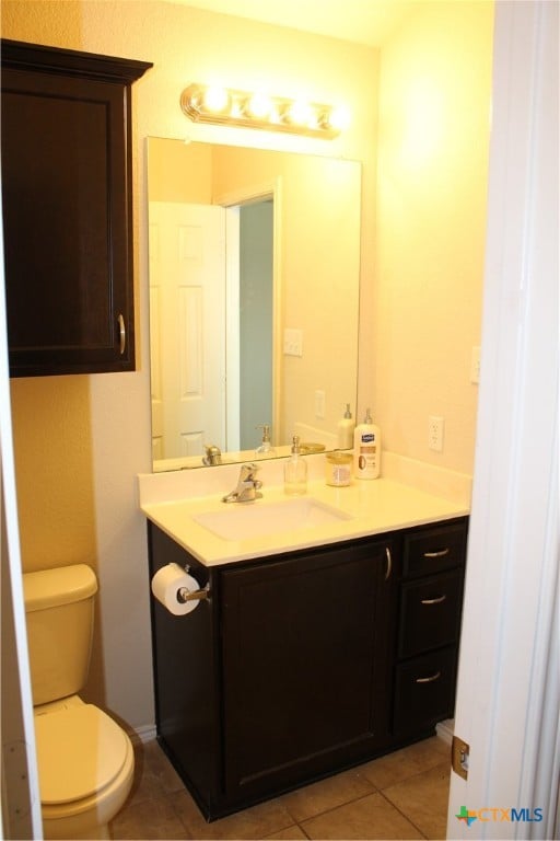 bathroom featuring tile patterned flooring, vanity, and toilet